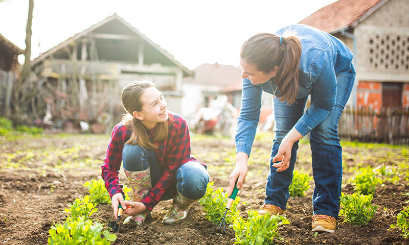 Mutter und Tochter arbeiten gemeinsam im Garten